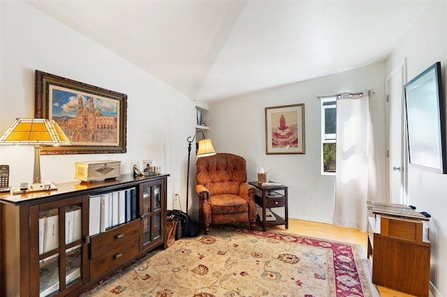 living area with light hardwood / wood-style floors and vaulted ceiling