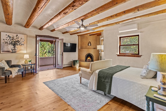 bedroom featuring light hardwood / wood-style floors, a wall unit AC, and multiple windows