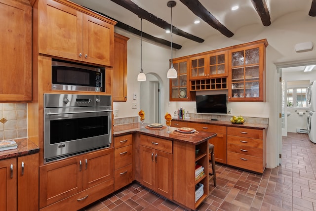 kitchen featuring beam ceiling, kitchen peninsula, stainless steel appliances, dark stone countertops, and decorative light fixtures