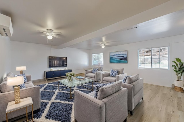 living area with light wood-type flooring, a wall mounted air conditioner, and ceiling fan