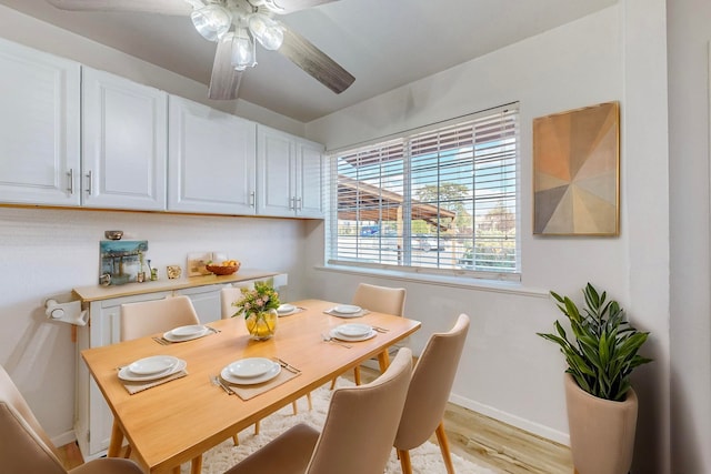 dining space featuring ceiling fan, light wood-style flooring, and baseboards