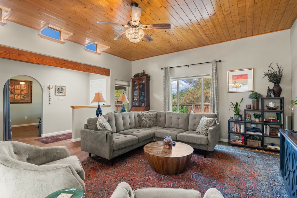 living room with ceiling fan, dark hardwood / wood-style floors, and wooden ceiling