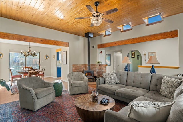 living room with wood ceiling, a wood stove, ceiling fan with notable chandelier, and hardwood / wood-style floors