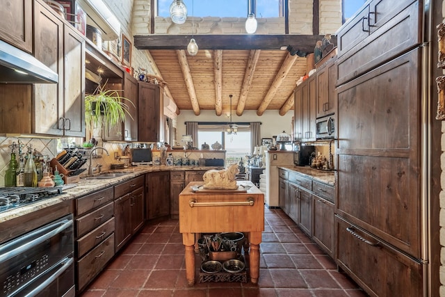 kitchen featuring appliances with stainless steel finishes, pendant lighting, sink, decorative backsplash, and beam ceiling