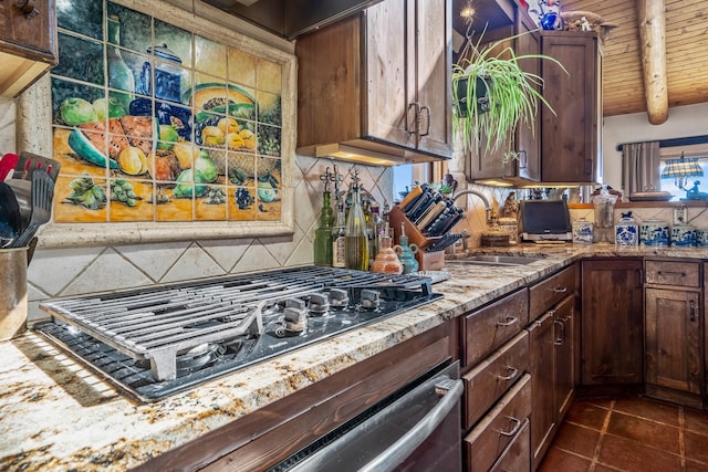 kitchen with sink, beam ceiling, light stone counters, black gas cooktop, and backsplash