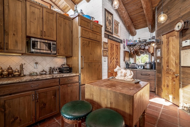 kitchen with wood ceiling, paneled built in fridge, lofted ceiling with beams, and decorative backsplash