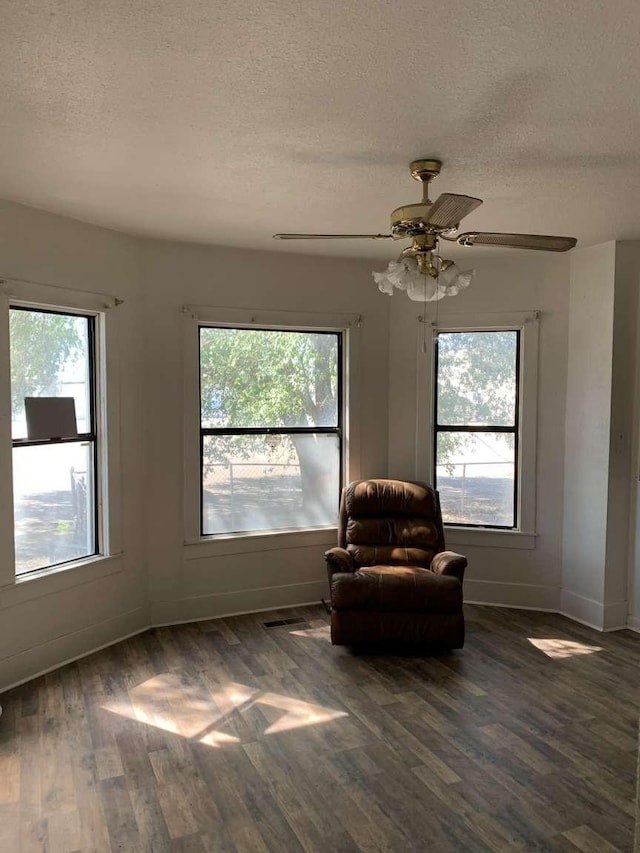 unfurnished room featuring a textured ceiling, ceiling fan, and dark hardwood / wood-style floors