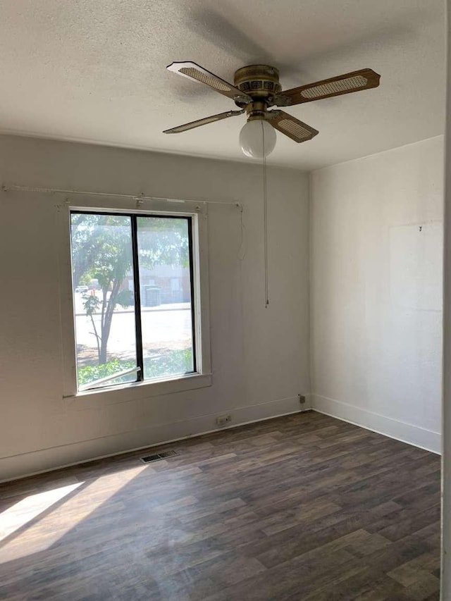 unfurnished room featuring a textured ceiling, dark hardwood / wood-style floors, and ceiling fan