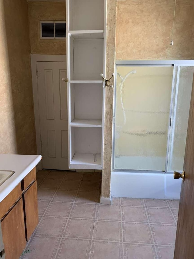 bathroom featuring vanity and bath / shower combo with glass door