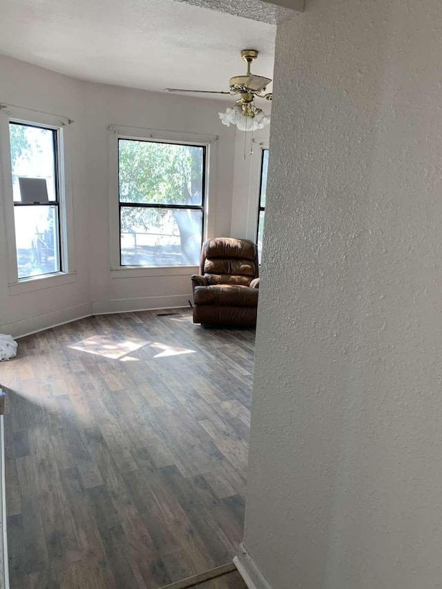 unfurnished living room featuring a textured ceiling, hardwood / wood-style flooring, plenty of natural light, and ceiling fan