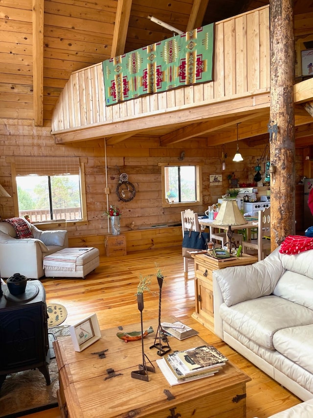 living room featuring beamed ceiling, wood-type flooring, and a wealth of natural light