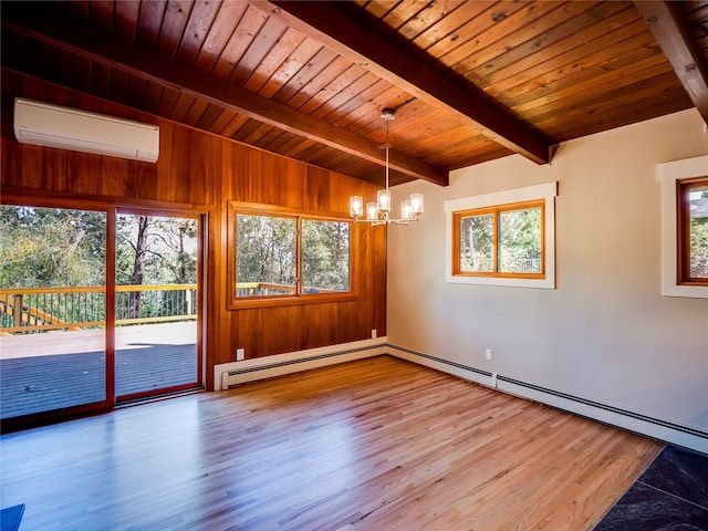 spare room featuring a wall unit AC, a healthy amount of sunlight, and wood-type flooring