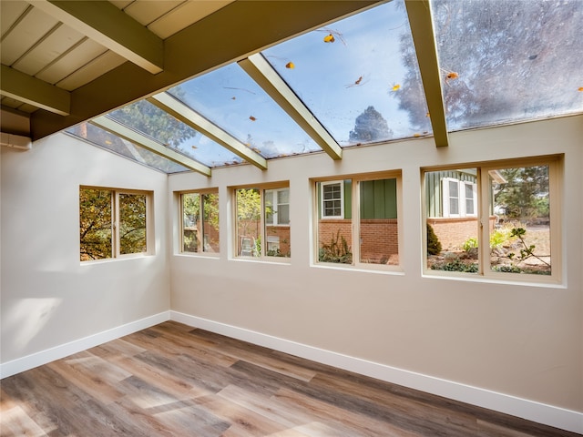 unfurnished sunroom with lofted ceiling with beams