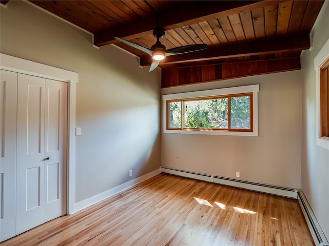 unfurnished bedroom featuring a baseboard heating unit, beamed ceiling, wooden ceiling, and light wood-type flooring