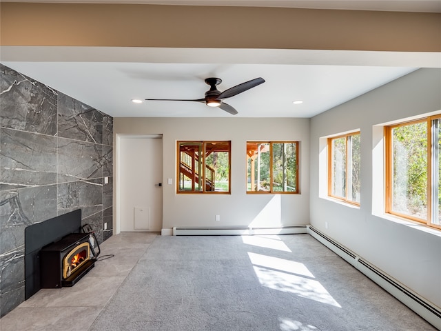 unfurnished living room with tile walls, a baseboard radiator, a wood stove, and ceiling fan