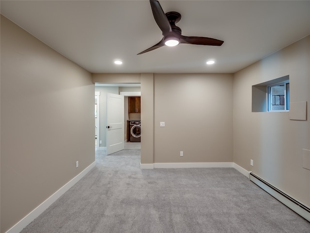 unfurnished room with a baseboard radiator, ceiling fan, light colored carpet, and washer / clothes dryer