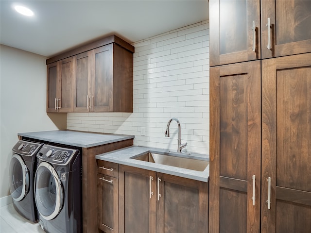 laundry room with cabinets, washer and dryer, and sink