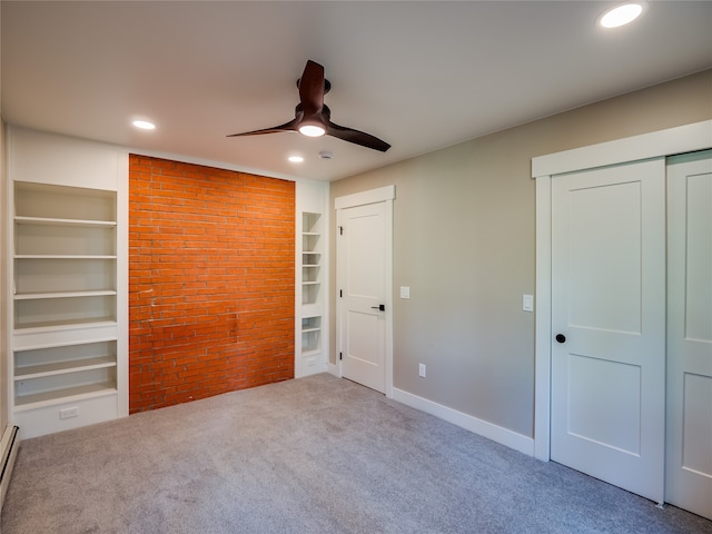 unfurnished bedroom with light carpet, a baseboard radiator, and ceiling fan