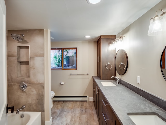 full bathroom featuring toilet, separate shower and tub, a baseboard heating unit, hardwood / wood-style floors, and vanity