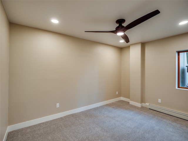 carpeted spare room featuring a baseboard heating unit and ceiling fan