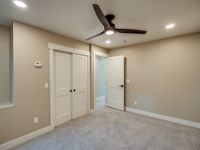 unfurnished bedroom featuring light colored carpet, a closet, and ceiling fan