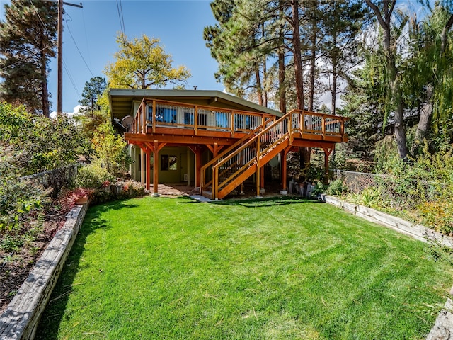 rear view of property featuring a wooden deck and a yard