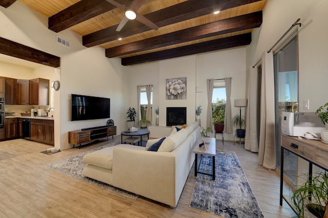 living room with sink, wood ceiling, light hardwood / wood-style floors, ceiling fan, and beamed ceiling