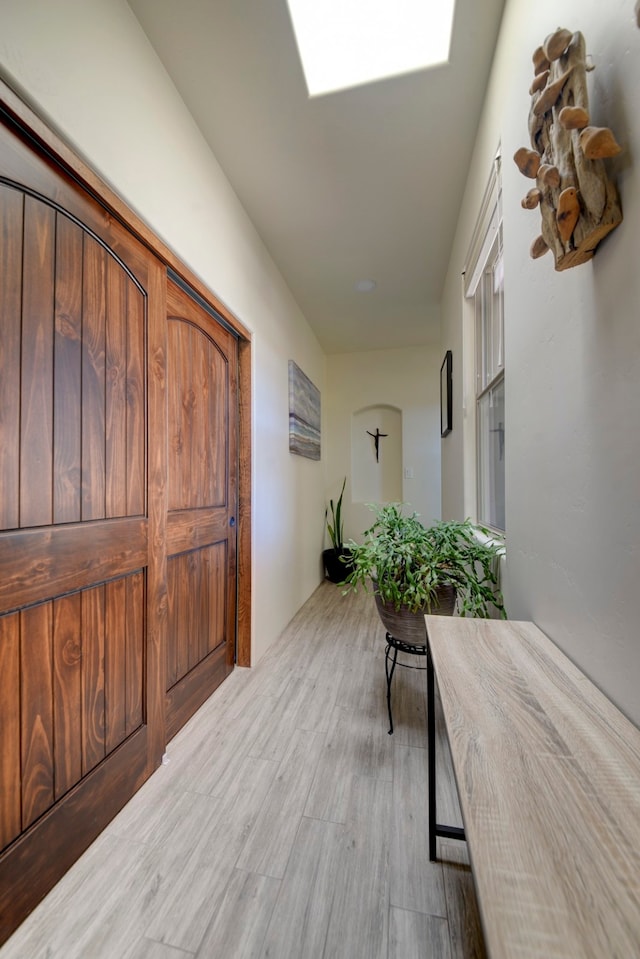 corridor with light hardwood / wood-style floors