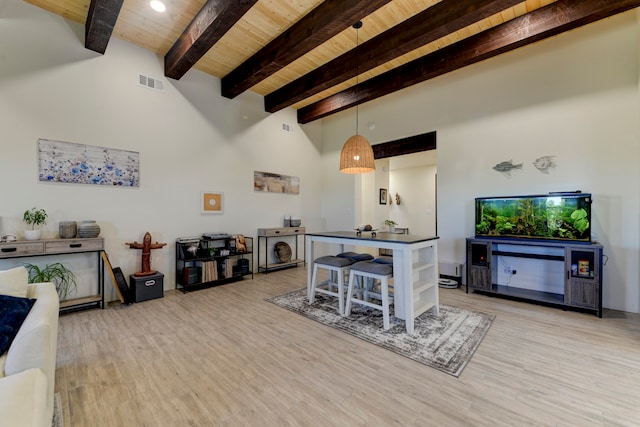 interior space featuring a towering ceiling, wooden ceiling, light hardwood / wood-style flooring, and beamed ceiling