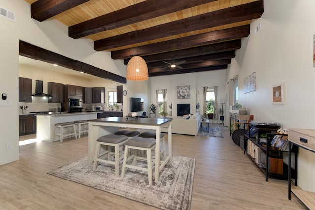 interior space with light hardwood / wood-style floors, wood ceiling, and beamed ceiling