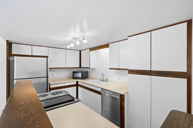 kitchen with sink, dishwasher, white refrigerator, a textured ceiling, and white cabinets