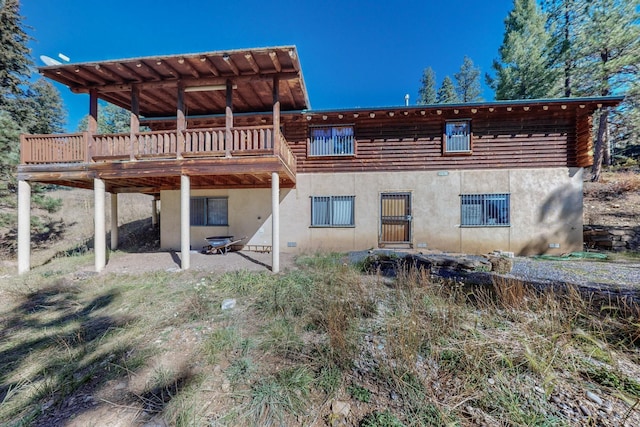 12 Pine Ln, Terrero, NM 87573 - back of house with stucco siding, a wooden deck, and a patio