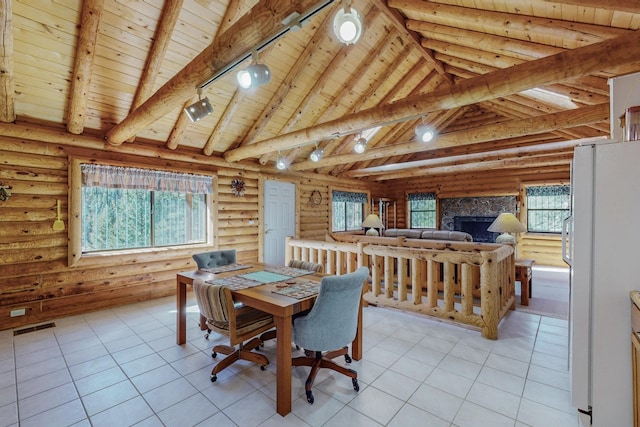 12 Pine Ln, Terrero, NM 87573 - dining space with wooden ceiling with exposed beams, light tile patterned floors, high vaulted ceiling, track lighting, and a fireplace