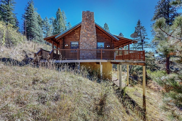 12 Pine Ln, Terrero, NM 87573 - back of house with log exterior, a chimney, and a wooden deck