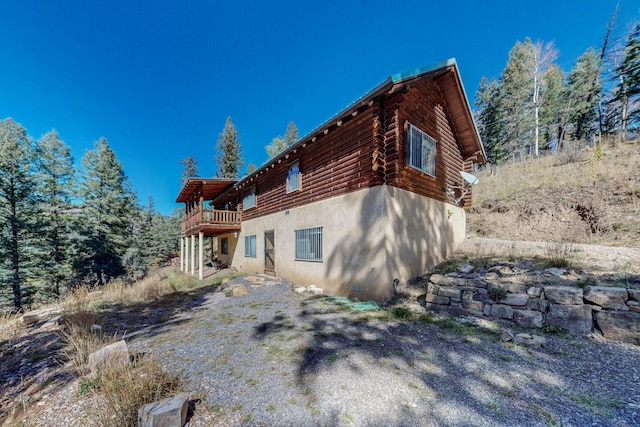 12 Pine Ln, Terrero, NM 87573 - back of house featuring stucco siding, log exterior, and a wooden deck