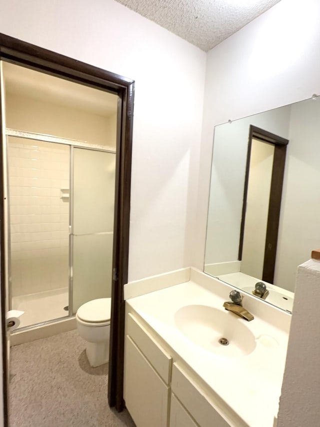 bathroom featuring vanity, toilet, a textured ceiling, and walk in shower