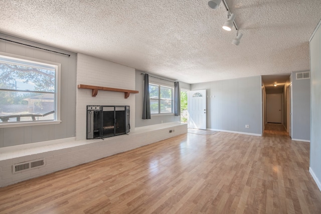 unfurnished living room featuring a textured ceiling, a fireplace, and hardwood / wood-style floors