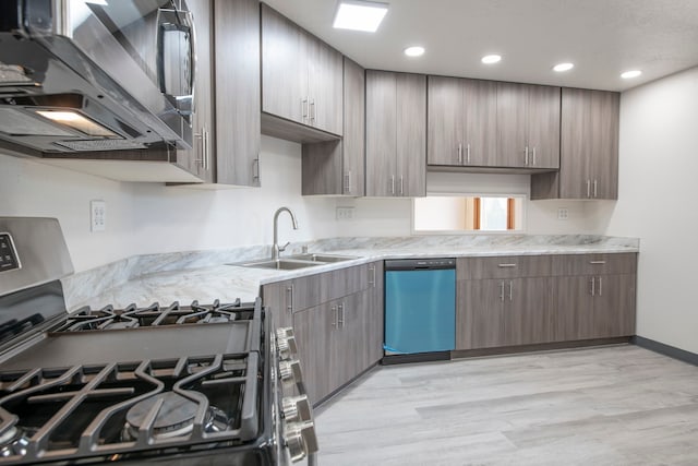 kitchen featuring light stone countertops, stainless steel appliances, sink, and light wood-type flooring