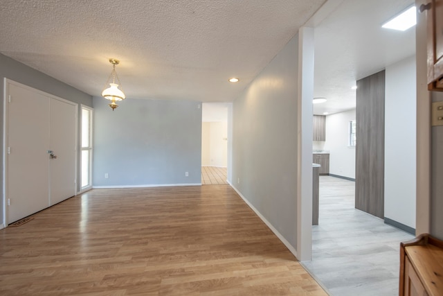 foyer with a textured ceiling, light hardwood / wood-style floors, and plenty of natural light