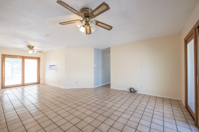 tiled spare room with a textured ceiling and ceiling fan