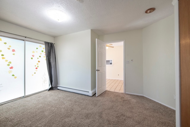 spare room with a textured ceiling, baseboard heating, and light colored carpet