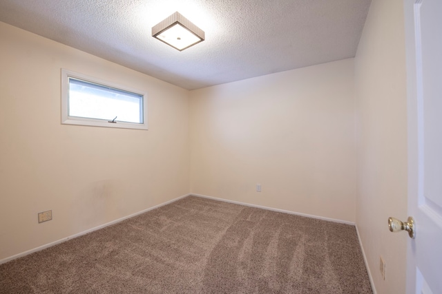 carpeted empty room with a textured ceiling