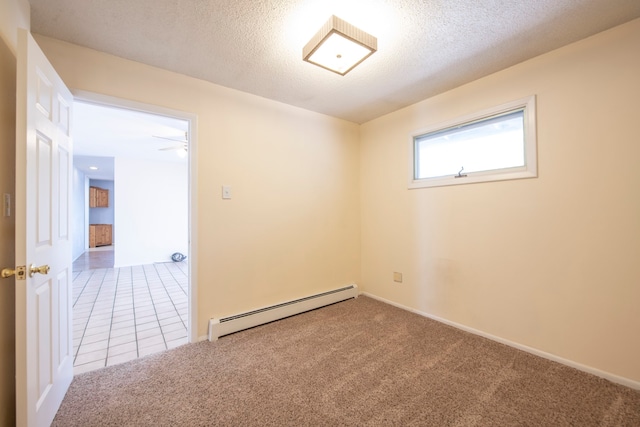 empty room featuring a textured ceiling, carpet flooring, a baseboard radiator, and ceiling fan