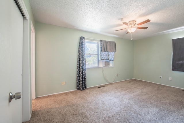 unfurnished bedroom with ceiling fan, light carpet, and a textured ceiling