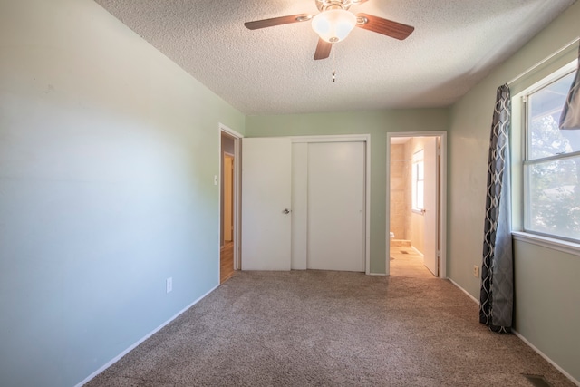 unfurnished bedroom with a textured ceiling, ensuite bathroom, and ceiling fan