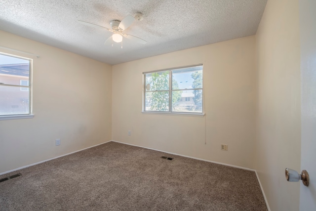 carpeted spare room with a textured ceiling and ceiling fan