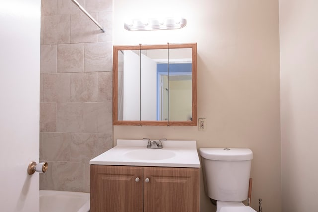 full bathroom featuring tiled shower / bath, vanity, and toilet