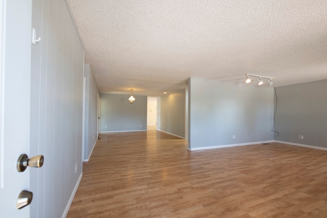 spare room with a textured ceiling and hardwood / wood-style flooring