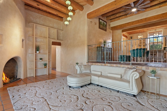 living room with beamed ceiling, a high ceiling, light tile patterned floors, and a fireplace