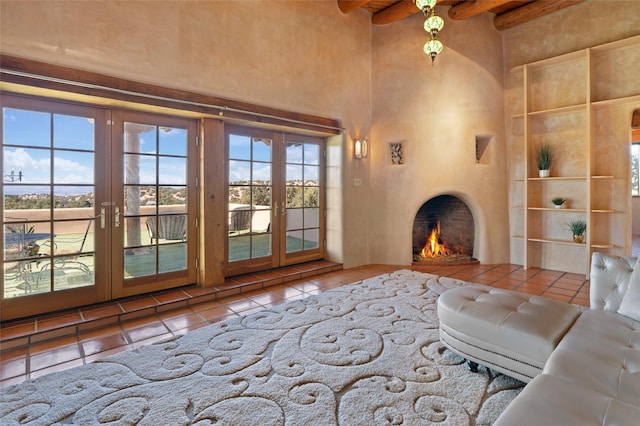 unfurnished living room featuring a high ceiling, tile patterned floors, beam ceiling, and french doors